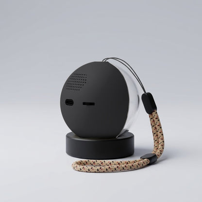 Parte trasera de la esfera Orbalma en color negro, con su botón y la entrada del cable